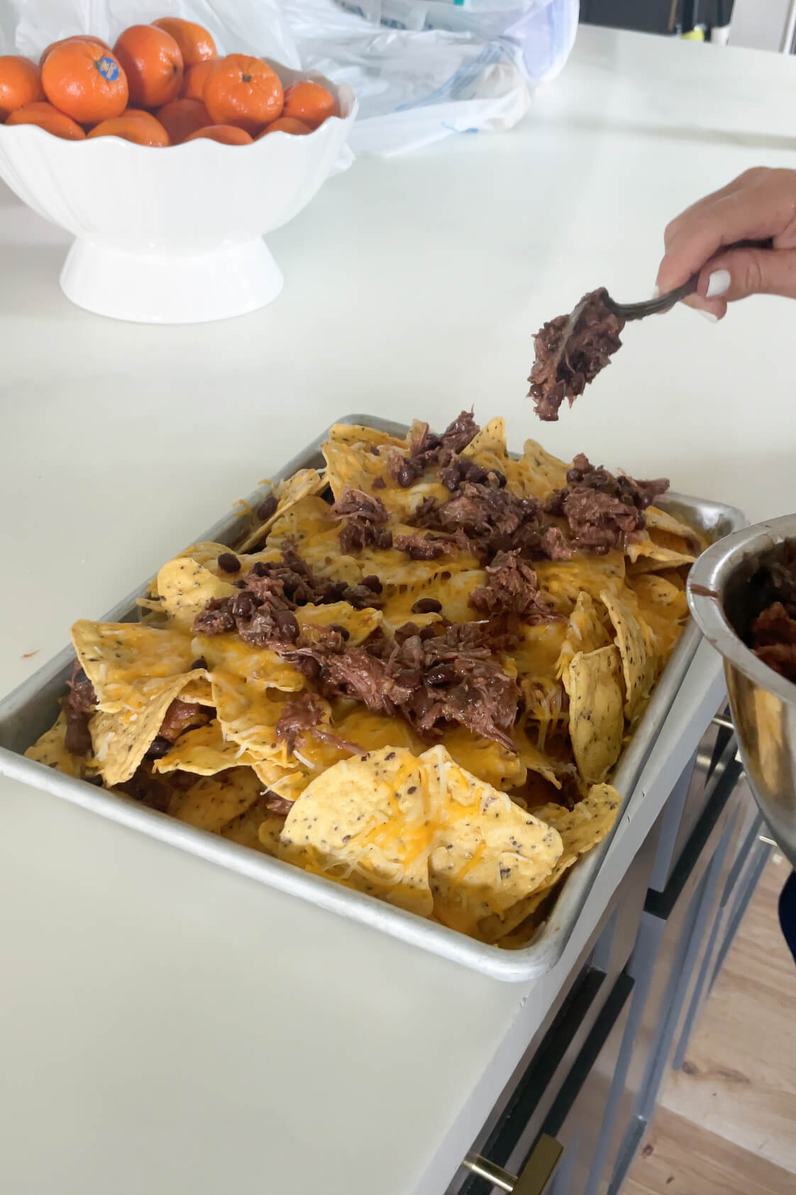 Adding more smoked brisket to the nachos. 